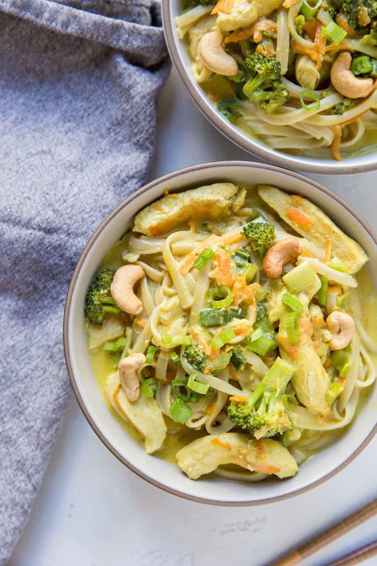 top down photo of two bowls of curry with noodles with a napkin to the side and chopsticks