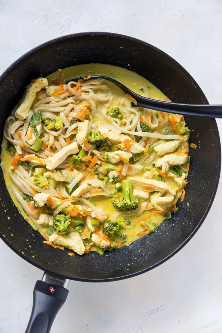 top down wok of curry with noodles, chicken and vegetables