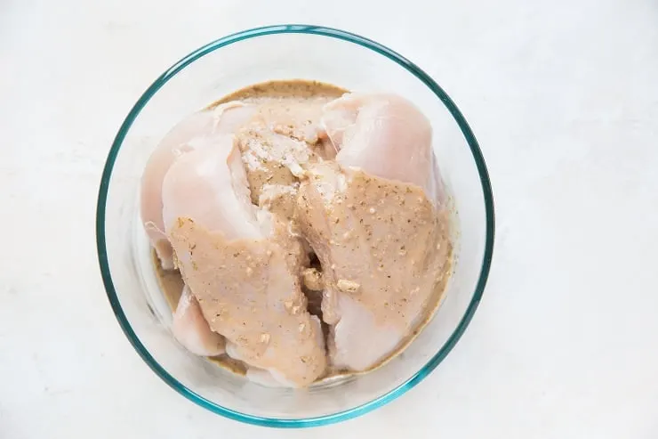 chicken in tupperware with marinade poured on top