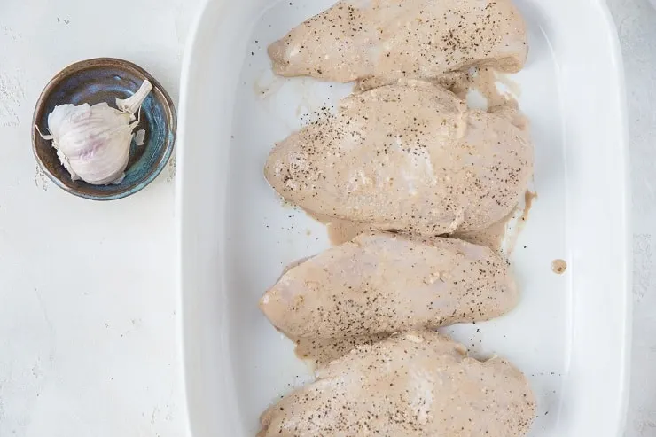 Balsamic marinated chicken breasts in a casserole dish ready to bake