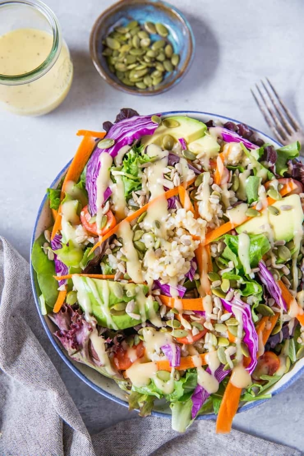 A really great summer salad recipe with greens, carrots, cabbage, avocado, brown rice and homemade dressing