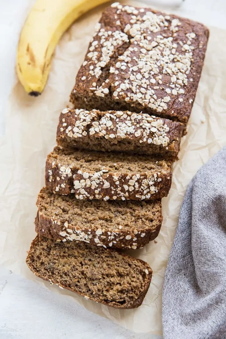 Oatmeal Banana Bread on parchment paper with a napkin and a banana