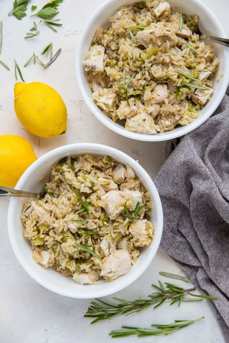 Two bowls of instant pot chicken and rice with napkin to the side and lemons