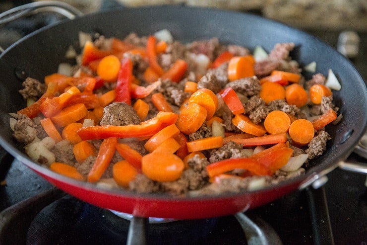 beef and vegetables cooking in a skillet