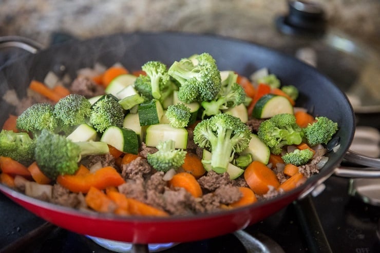 Skillet of vegetables and beef cooking on the stove top