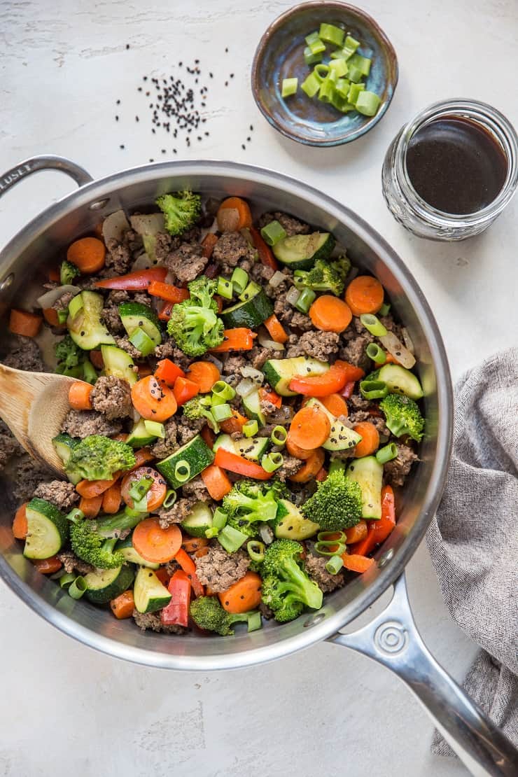 30-Minute Teriyaki Beef Skillet with Vegetables - a skillet, a napkin, a jar of teriyaki sauce and a bowl of chopped green onion