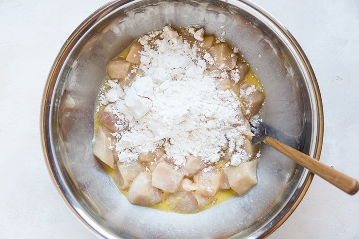 chopped chicken in beaten egg with flour
