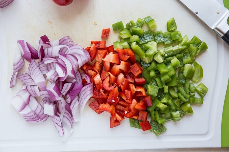 chopped onion and bell pepper on a cutting board