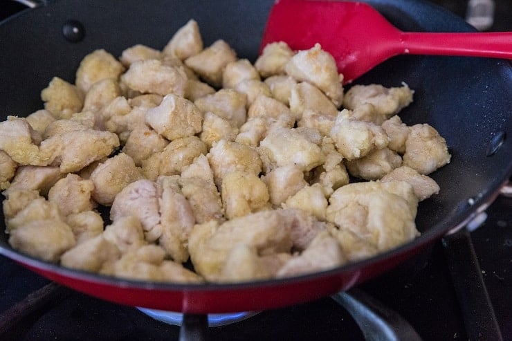 breaded chicken peices cooking in a skillet