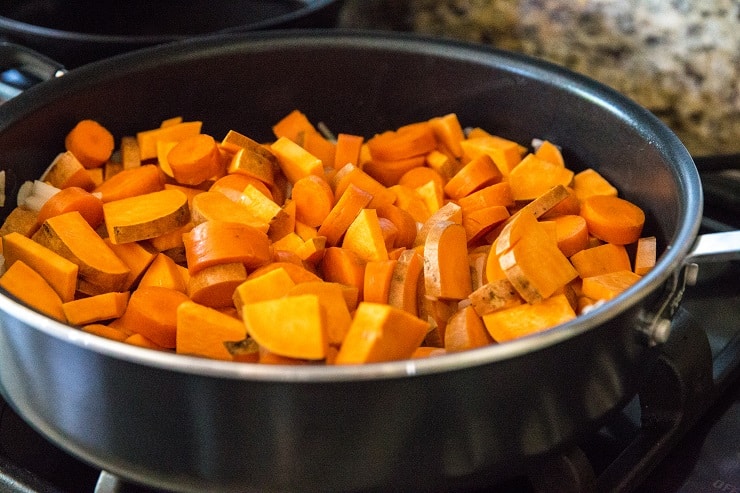 Sweet potatoes, carrots, and onion in a large skillet