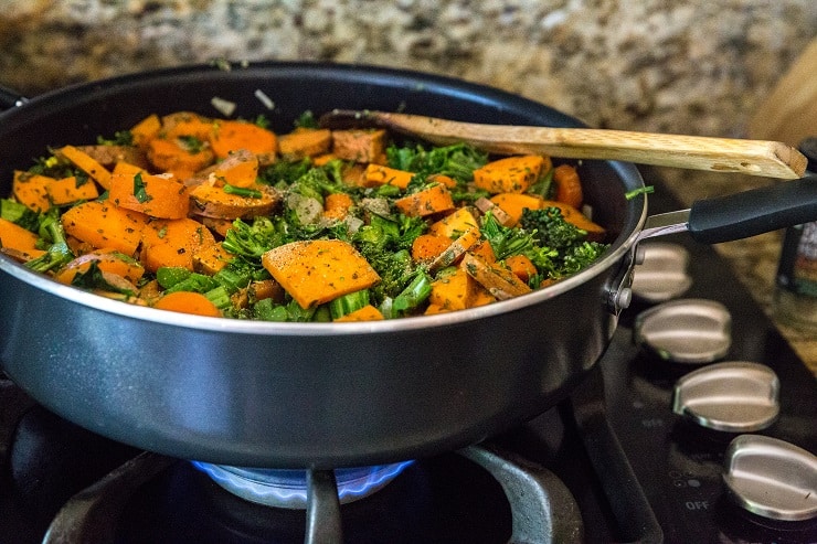 chopped broccoli, carrots, sweet potatoes and onion cooking in a big skillet with seasonings