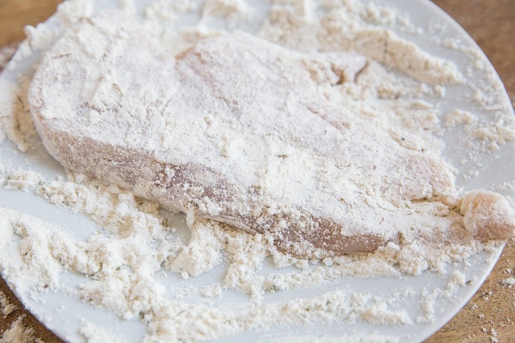 chicken breasts in flour mixture on a plate