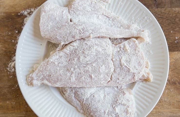 floured chicken on a plate
