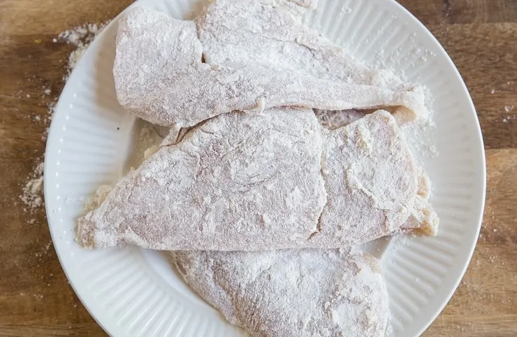 floured chicken on a plate