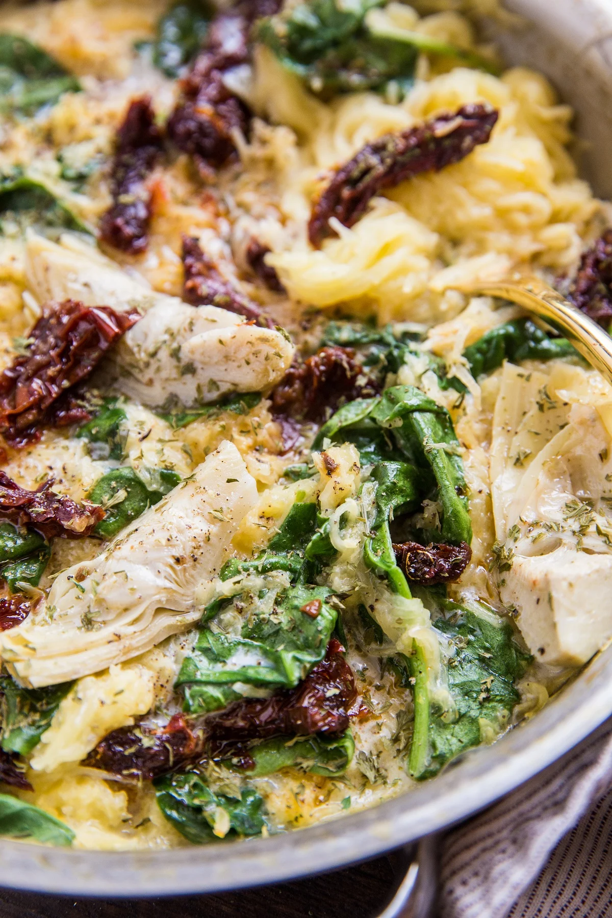 Vegan Tuscan Spaghetti Squash with sun-dried tomatoes, artichoke hearts and spinach - a creamy dairy-free spaghetti squash recipe that is paleo, low-carb and keto