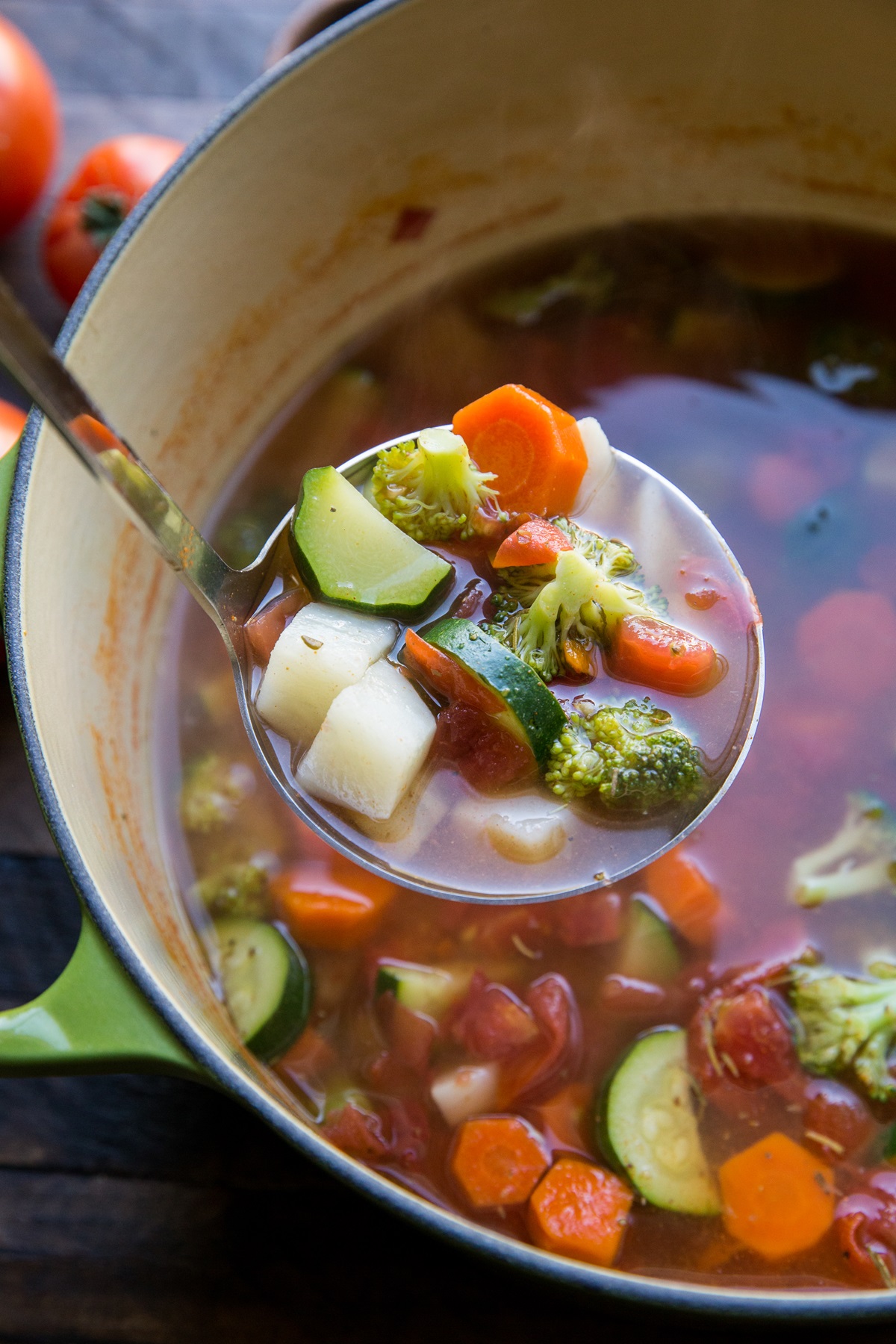 Big pot of vegetable soup with a ladle scooping some of the soup out to serve.