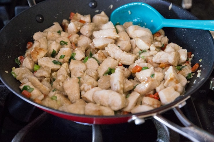 Chicken and vegetables cooking in a skillet for kung pao chicken