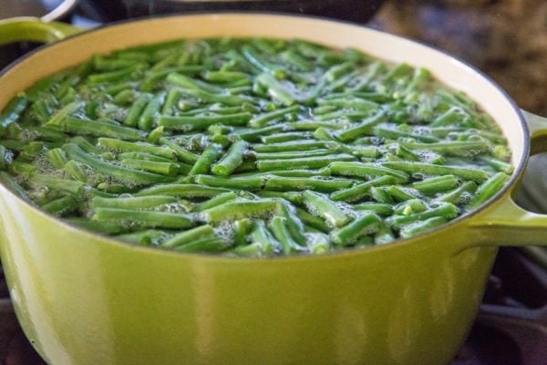 Green beans in a large pot boiling to soften up.