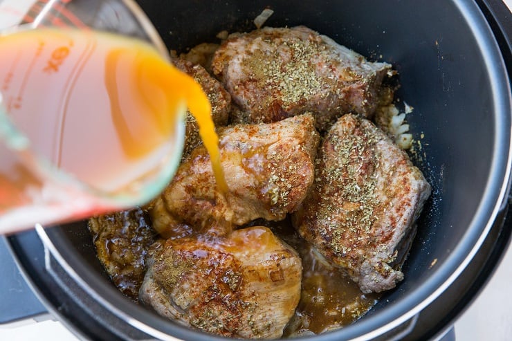 Pouring cider into an instant pot to make shredded pork