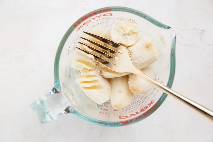 Mash bananas in a measuring cup or bowl