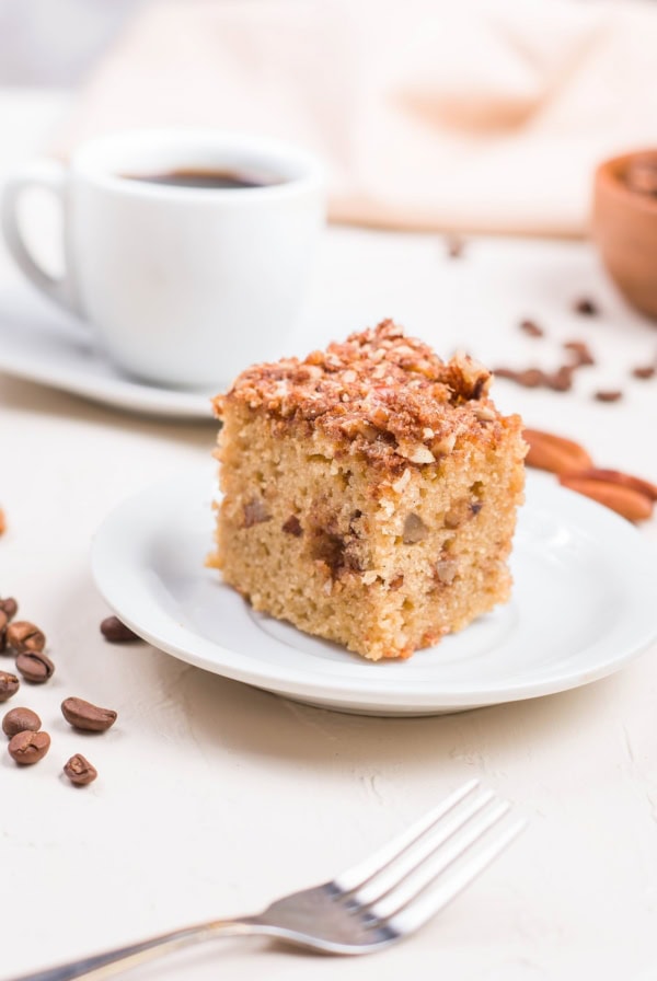 Slice of almond flour coffee cake on a plate with more slices in the background.