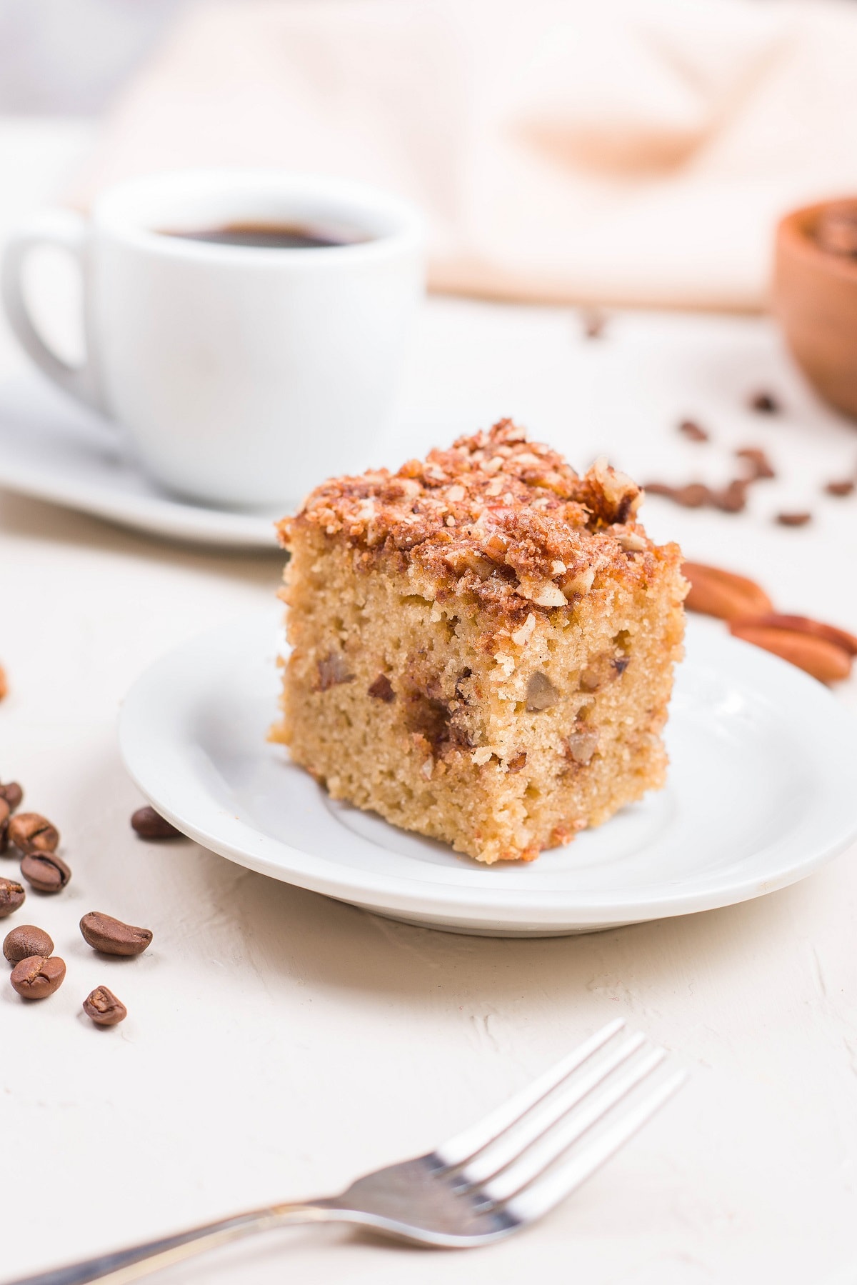 Slice of almond flour coffee cake on a plate with more slices in the background.