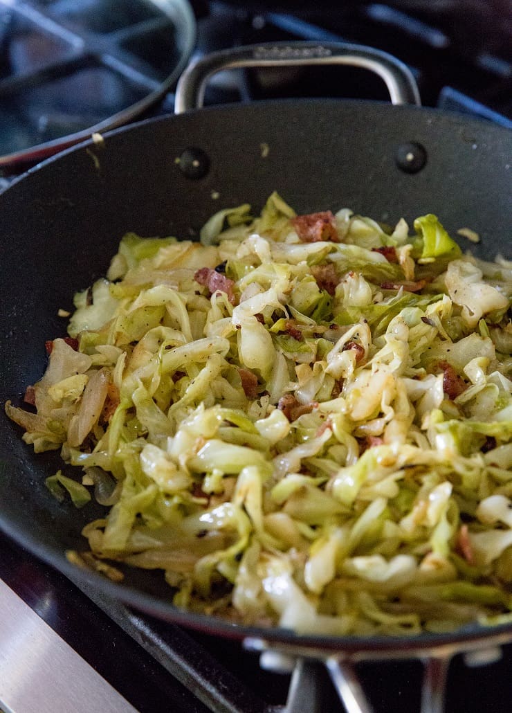 Caramelized cabbage in a skillet with bacon and onion