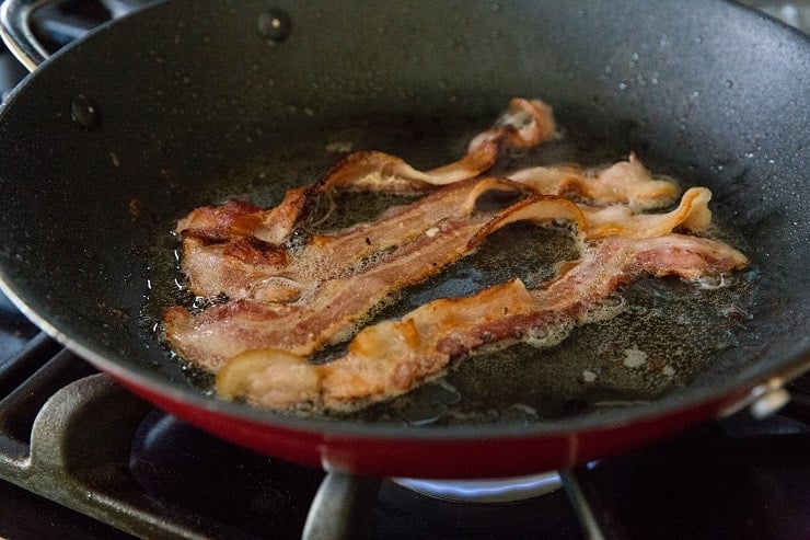 Cooking bacon in a skillet for caramelized cabbage