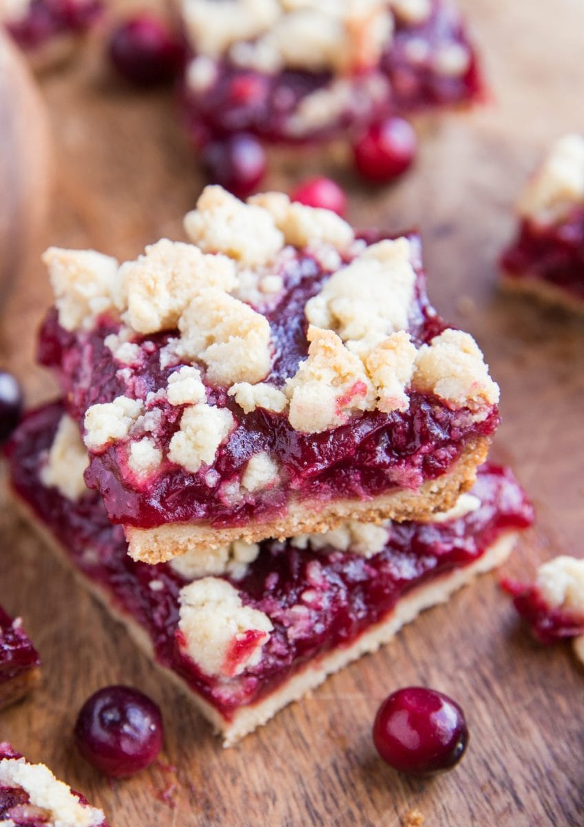 Stack of cranberry crumb bars on a cutting board.