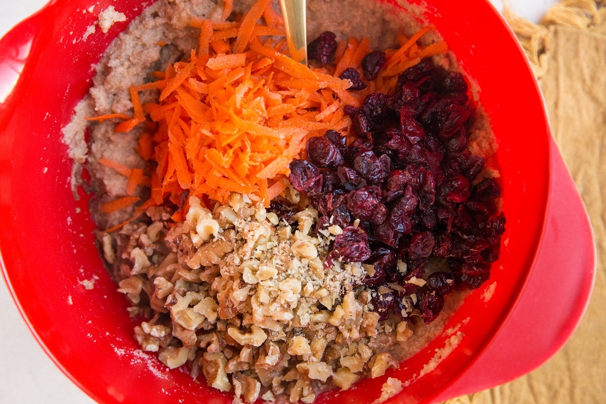 Ingredients for carrot cake muffins in a red mixing bowl