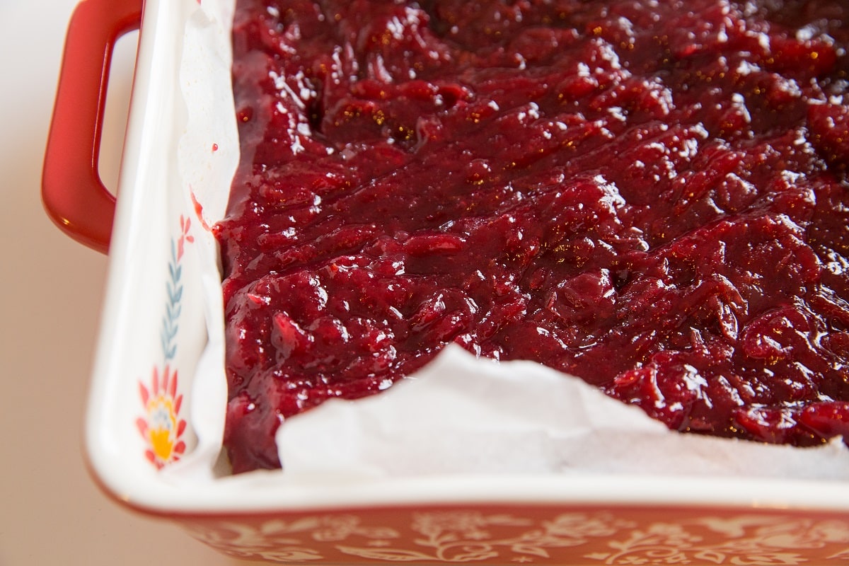 Cranberry filling on top of shortbread crust to make cranberry bars