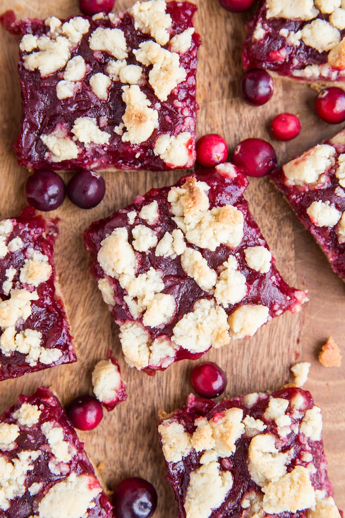 Top down photo of cranberry crumb bars sliced on a cutting board