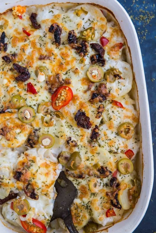 Mediterranean Scalloped Potatoes with sun-dried tomatoes, olives, and roasted bell peppers. A unique spin on classic scalloped potatoes for an amazing side dish!