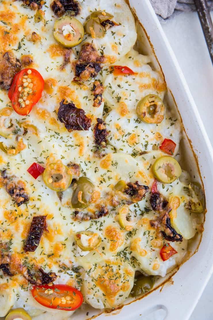 Mediterranean Scalloped Potatoes with sun-dried tomatoes, olives, and roasted bell peppers. A unique spin on classic scalloped potatoes for an amazing side dish!