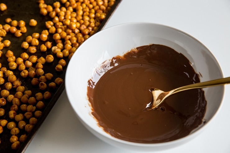 bowl of melted chocolate and sheetpan of roasted chickpeas