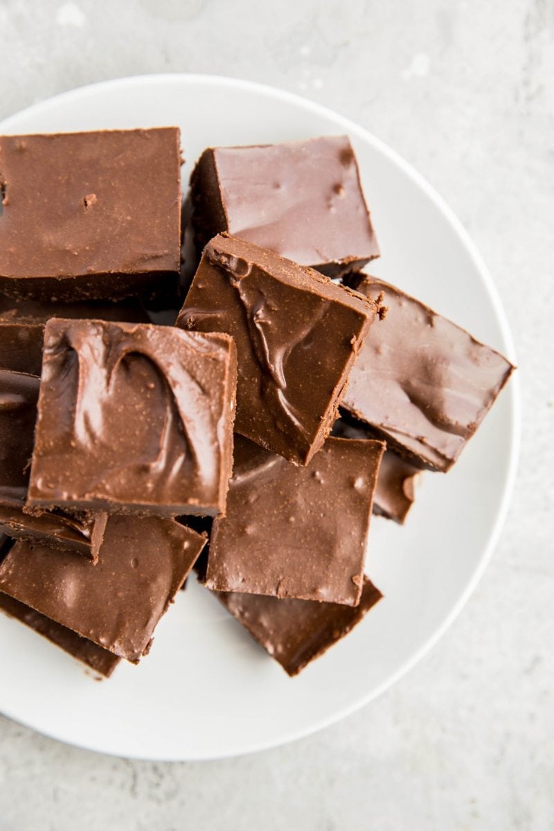 Plate of keto chocolate fudge cut into squares on a white background