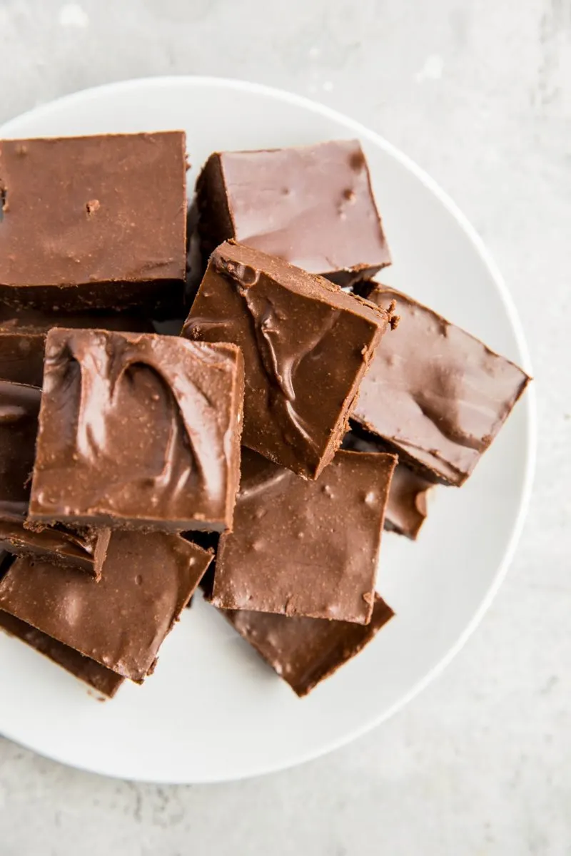Plate of keto chocolate fudge cut into squares on a white background