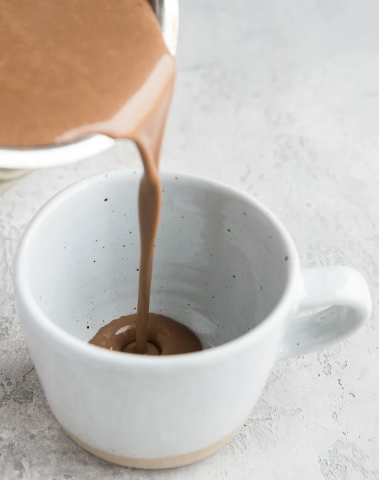 Pouring homemade hot chocolate into a mug