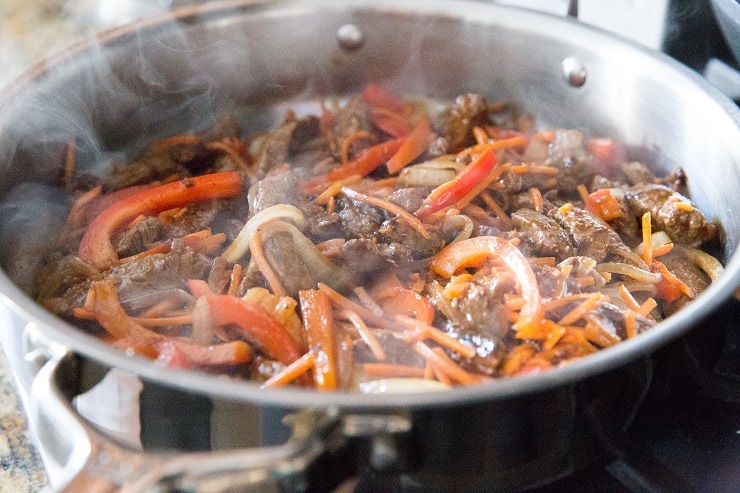 Szechuan beef cooking in a skillet