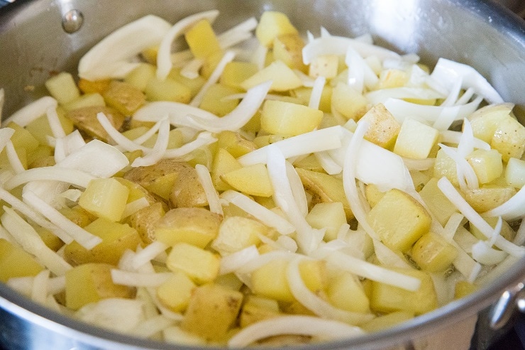 Add the onions to the skillet with the potatoes