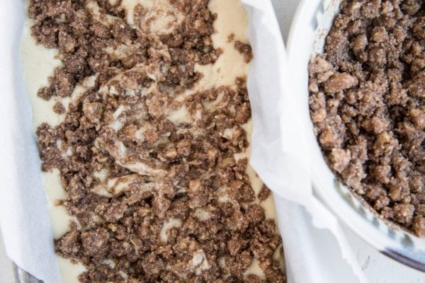 Loaf pan with half of the banana bread batter and half of the cinnamon swirl topping inside. About to repeat for the remaining batter and topping.