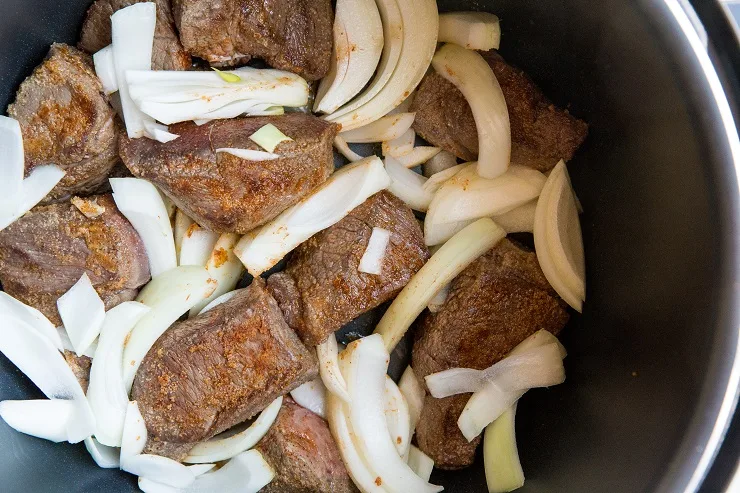 Add the onions, broth, and liquid aminos to the pressure cooker