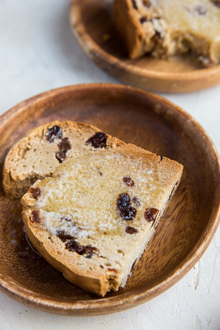 Slice of Irish soda bread with melted butter on a wooden plate