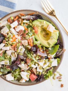 Amazing Filling Salad Recipe with chicken, avocado, spring greens, carrot, pumpkin seeds, pecans, green onion, and tomato