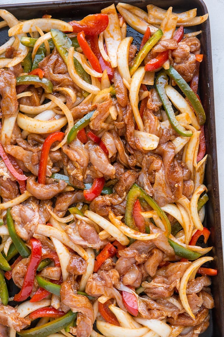 Ingredients for chicken fajitas on a baking sheet