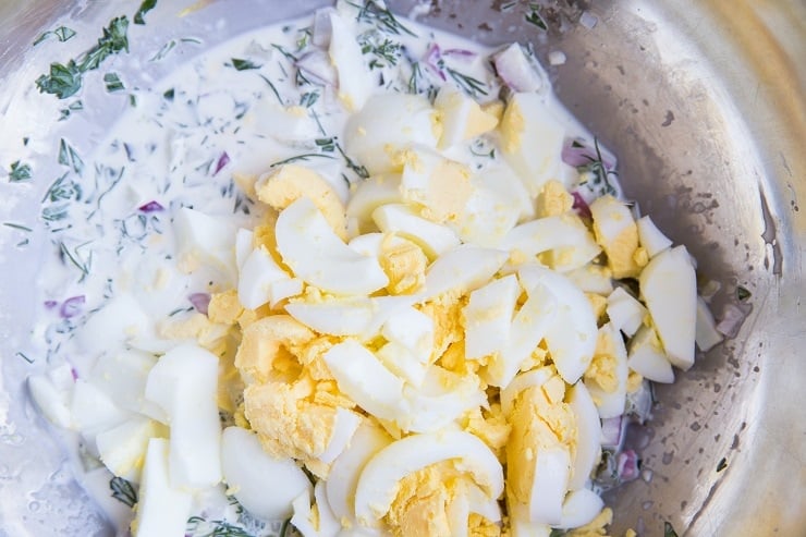 potato salad dressing in a mixing bowl with hard boiled egg