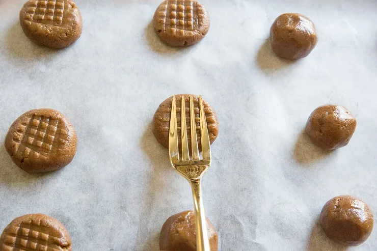Press balls of almond butter dough with a fork to shape them