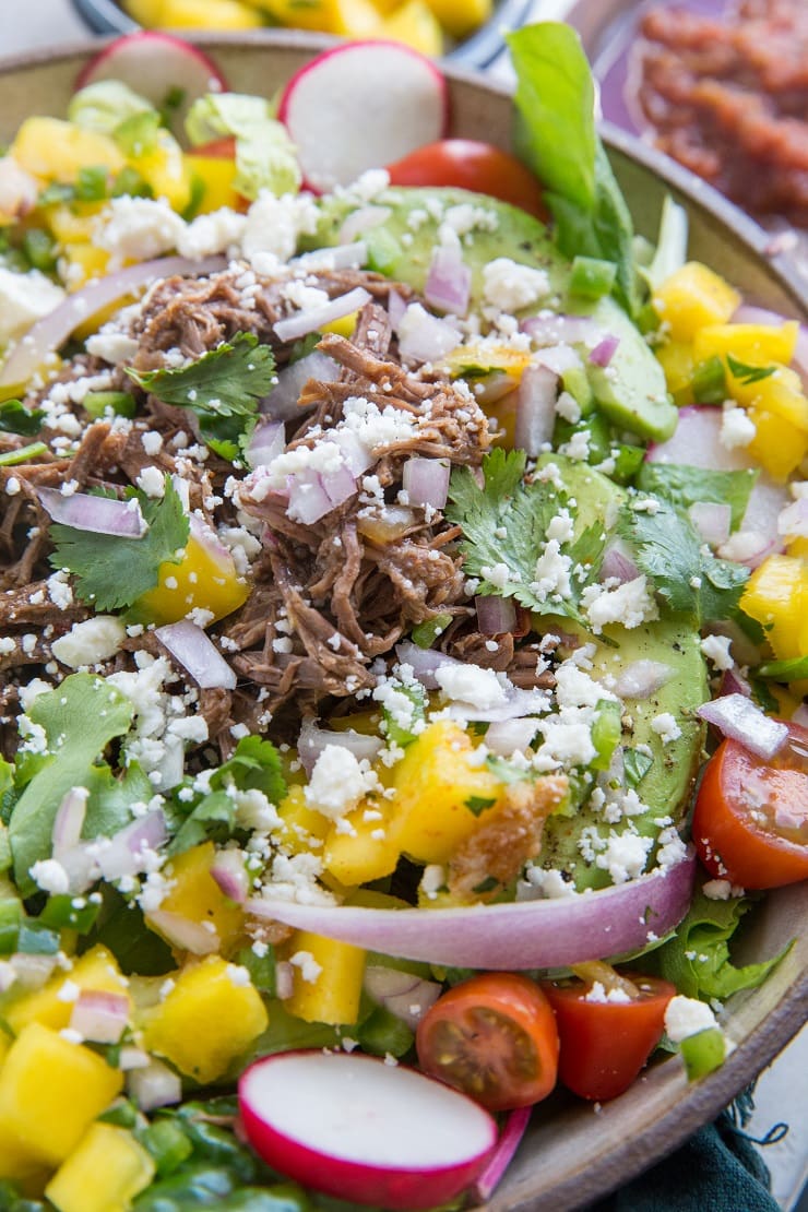 Instant Pot Shredded Beef Taco Salad with mango salsa, avocado and more! A healthy, satisfying entrée salad perfect for dinner. Make it for Cinco de Mayo!.