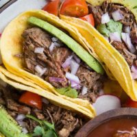 Instant Pot Shredded Beef Tacos with avocado, red onion and salsa. An amazingly flavorful, easy taco recipe!