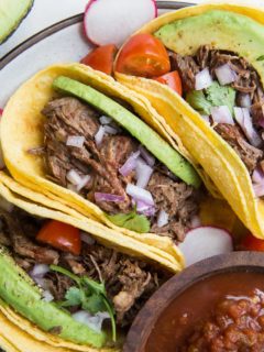 Instant Pot Shredded Beef Tacos with avocado, red onion and salsa. An amazingly flavorful, easy taco recipe!